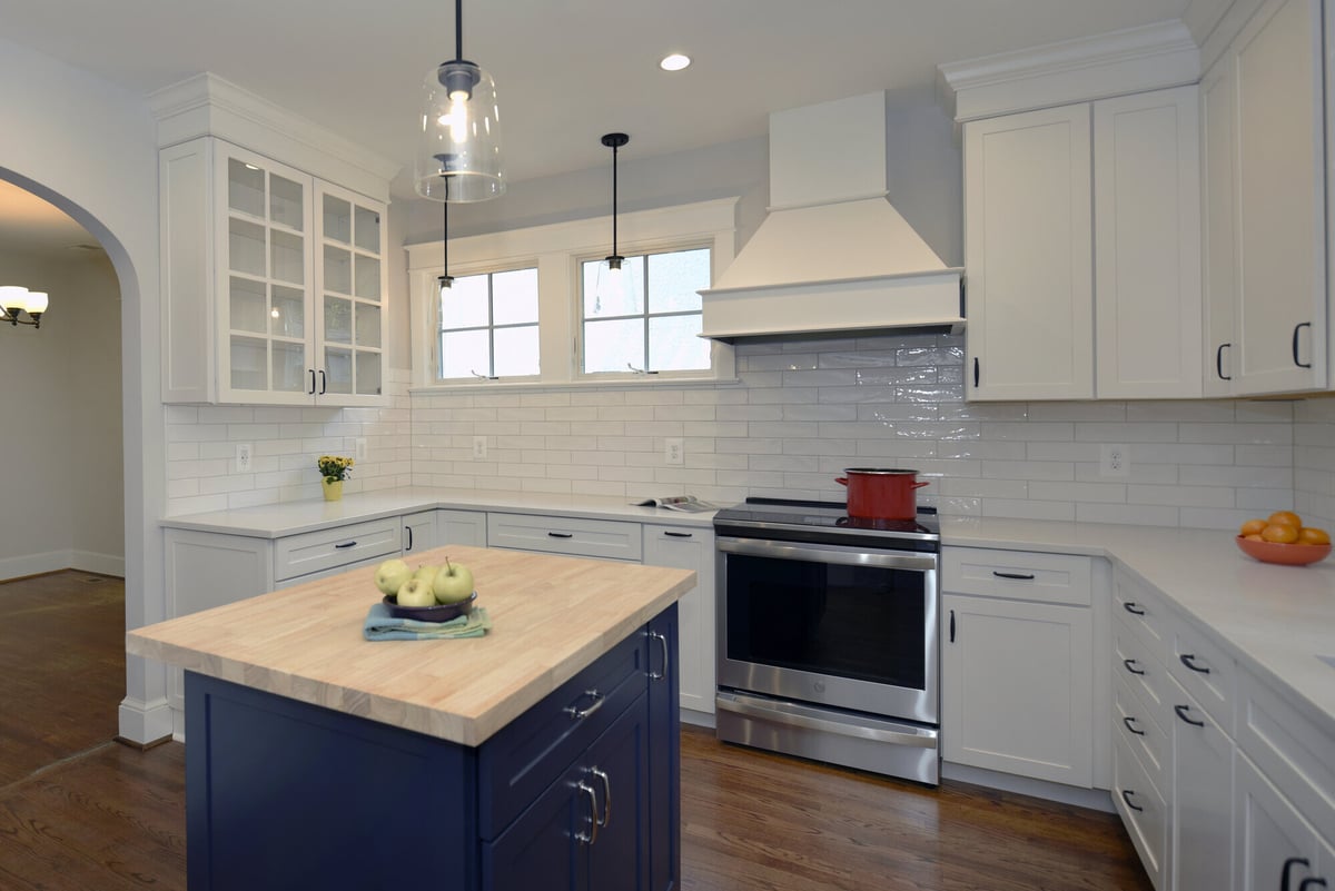 Bright kitchen with a navy island, white cabinets, and subway tile backsplash, remodeled by Villa Builders in Annapolis, MD