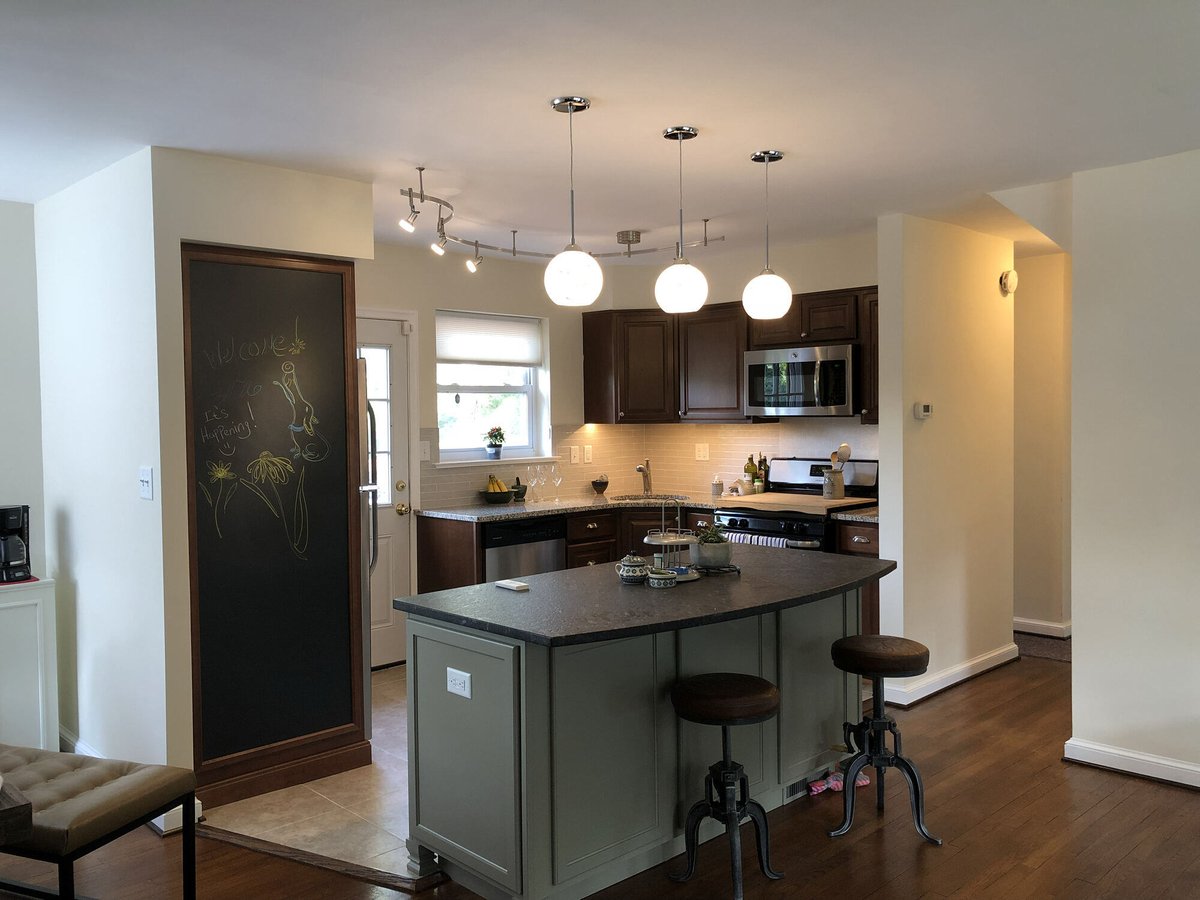 Kitchen renovation with central island, wood cabinetry, and pendant lights by Villa Builders in Annapolis, MD