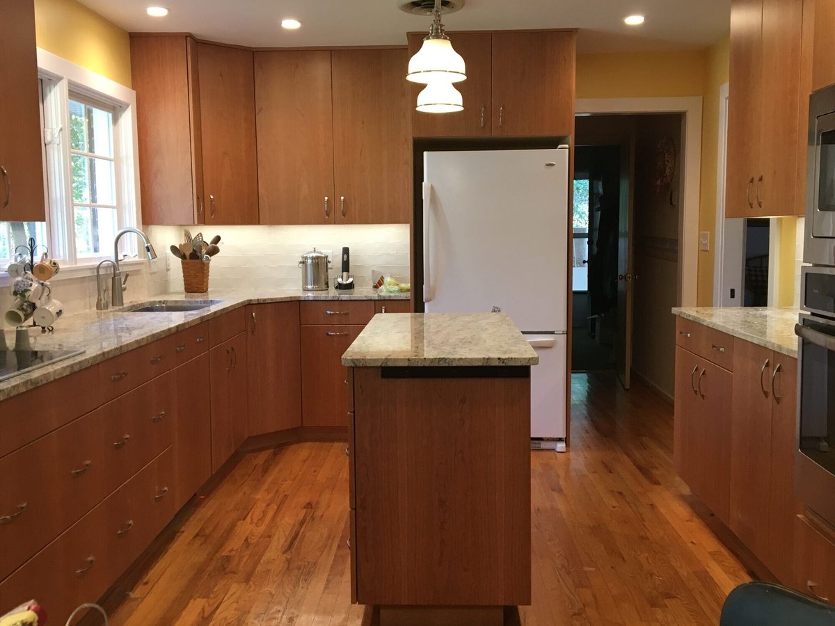 Modern kitchen with natural wood cabinets and a marble island, remodeled by Villa Builders in Annapolis, MD