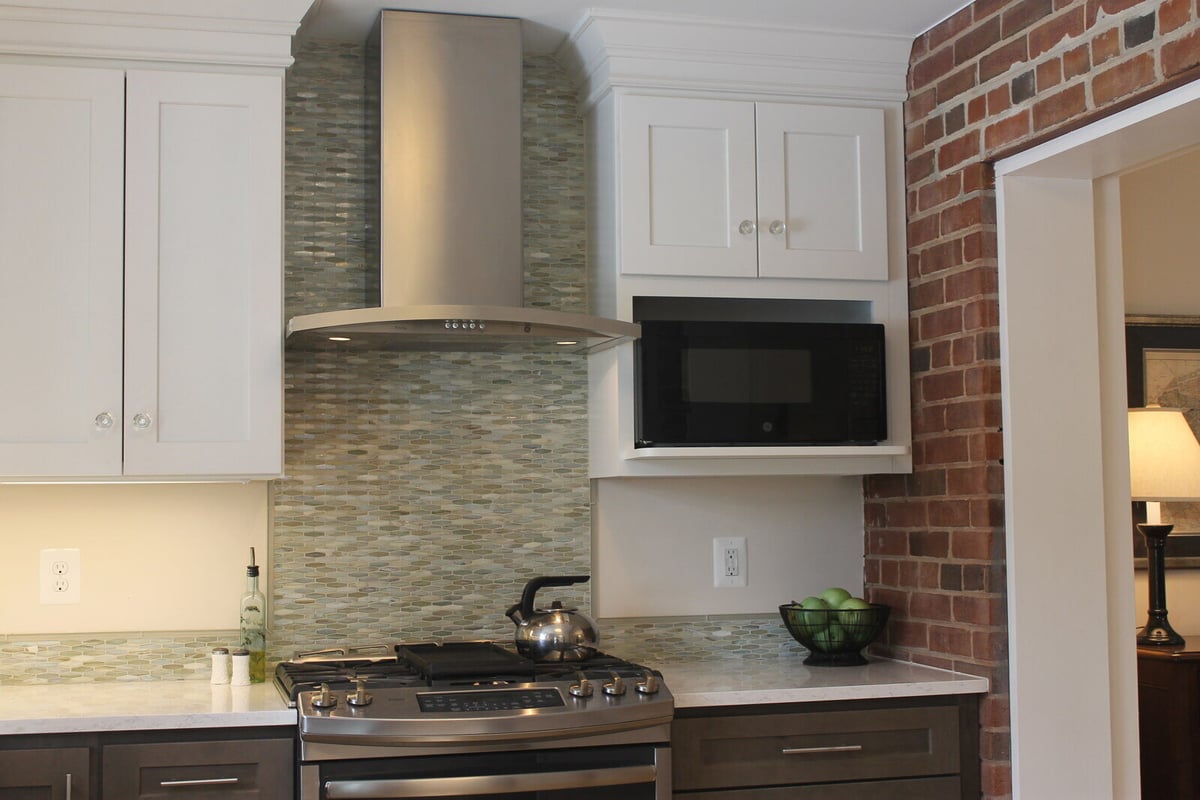 Modern kitchen remodel with a stainless steel hood and mosaic backsplash by Villa Builders in Annapolis, MD